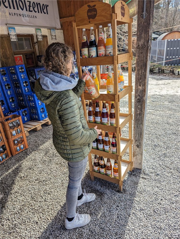 Kundin am Saftregal vor dem Markt